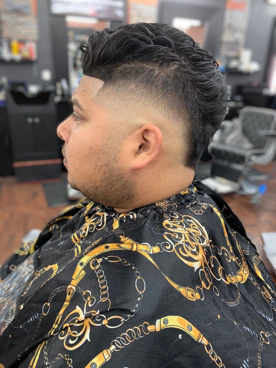 Client in a gold chain print cape showing a fresh drop fade with textured top