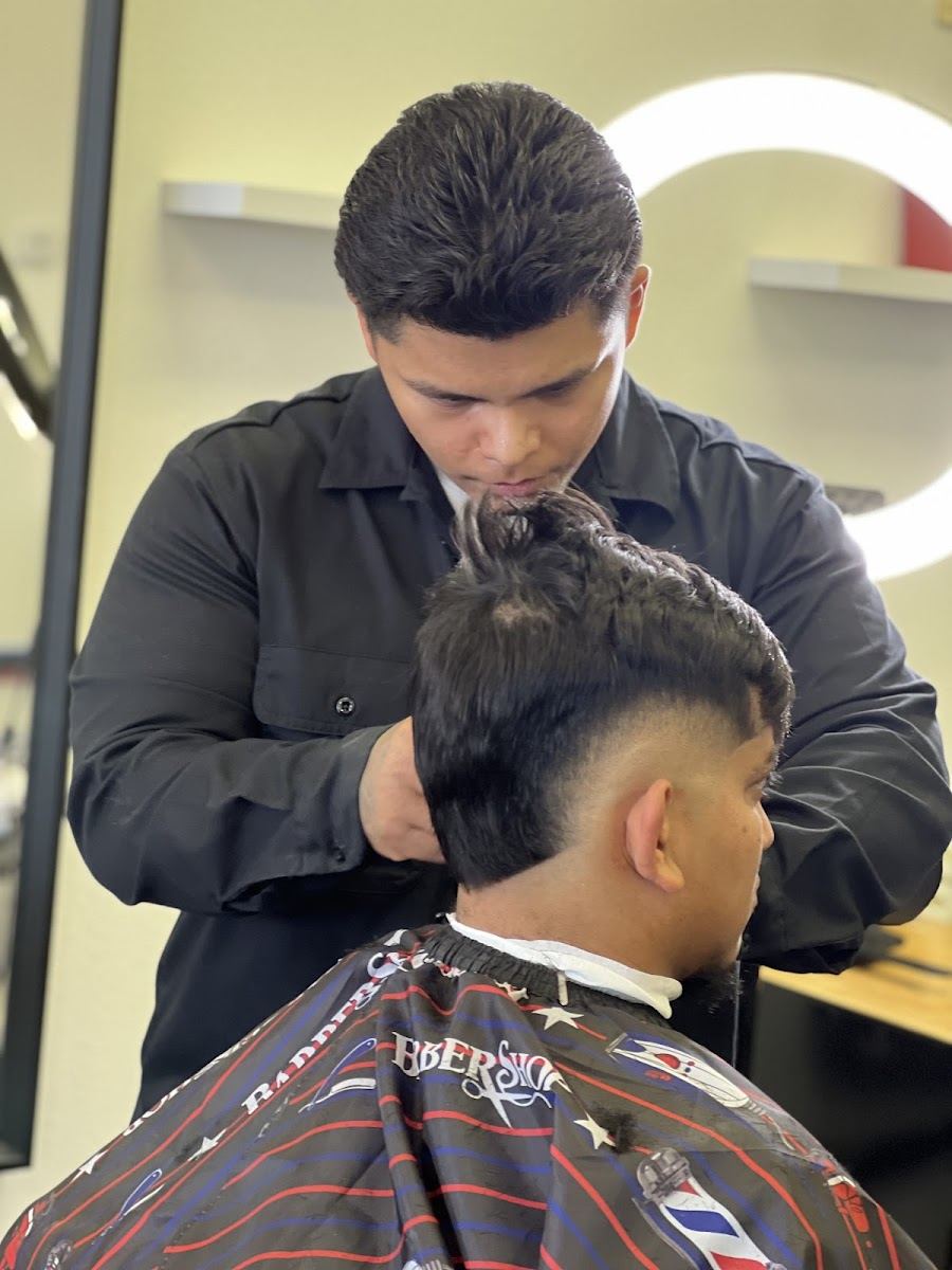 Barber cutting a young client's hair at the station