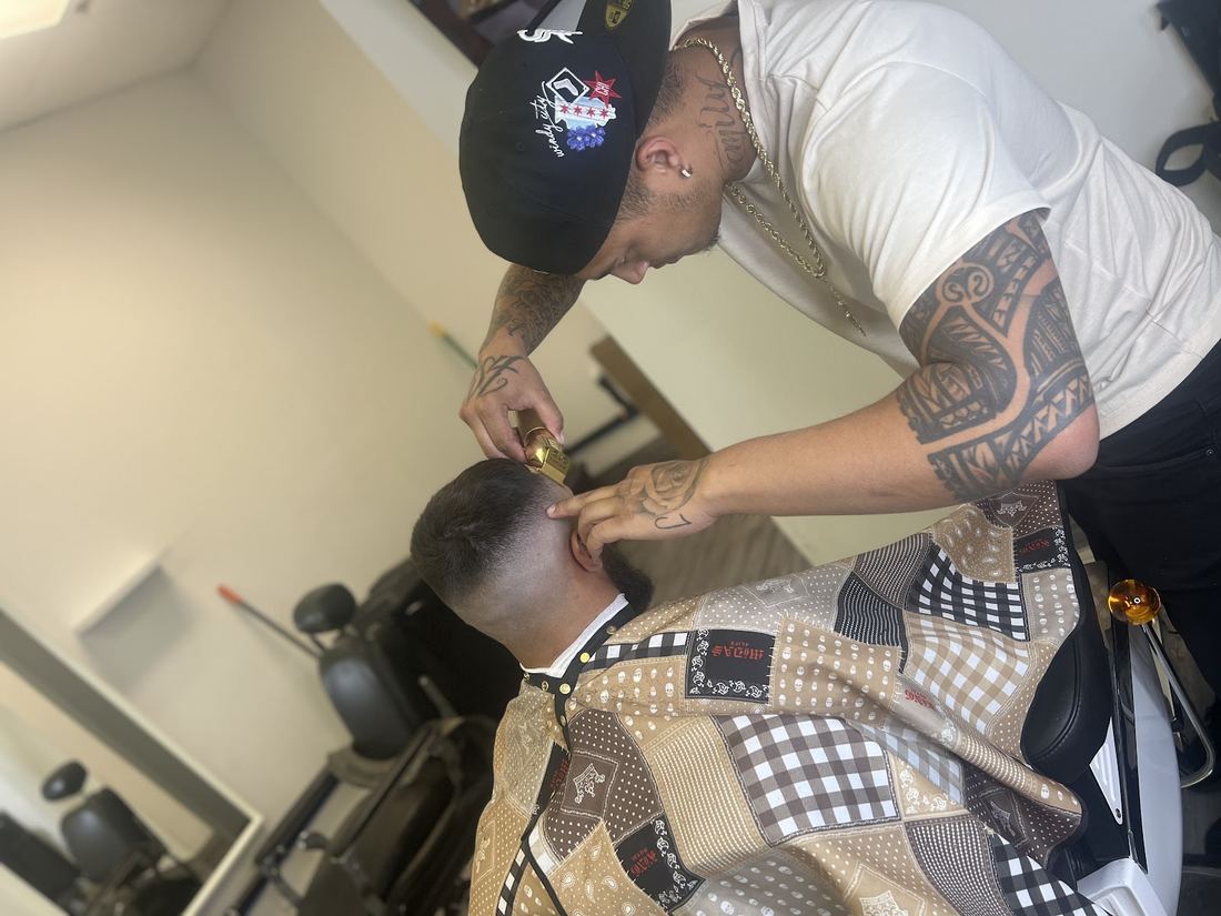 Barber detailing a client's beard line with a trimmer