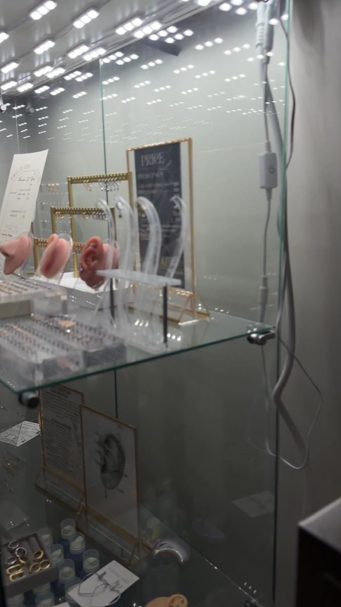 Glass case of piercing jewelry and display ears in the studio