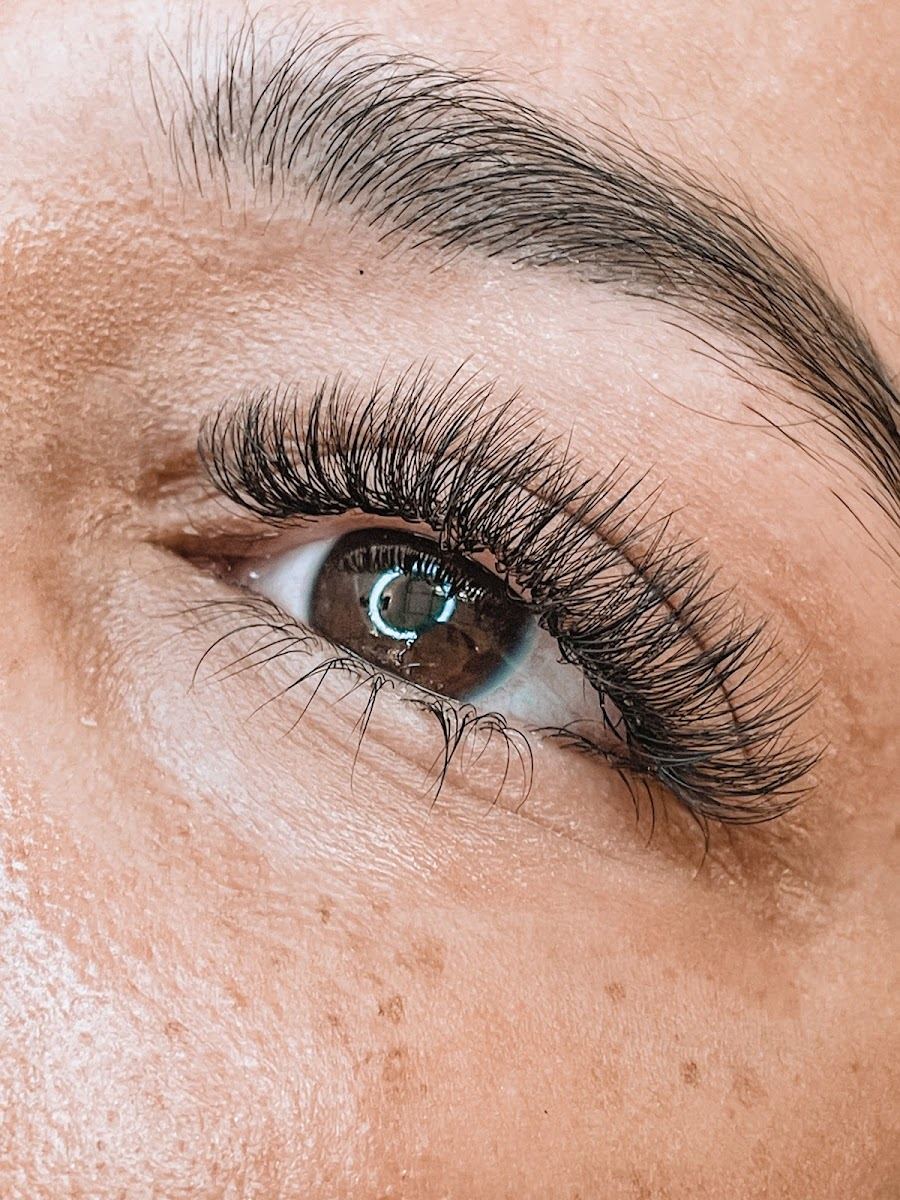 Extreme close up of a soft, fluffy lash extension set on a brown eye