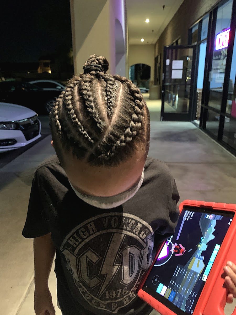 Top view of a young client's neat cornrow braids gathered into a bun