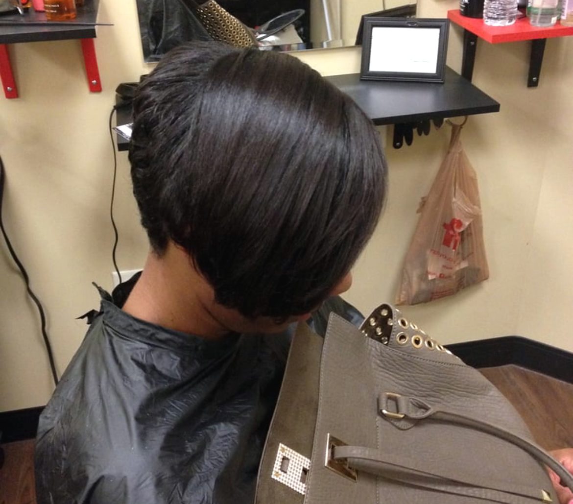 A short, glossy tapered bob seen from the side and back