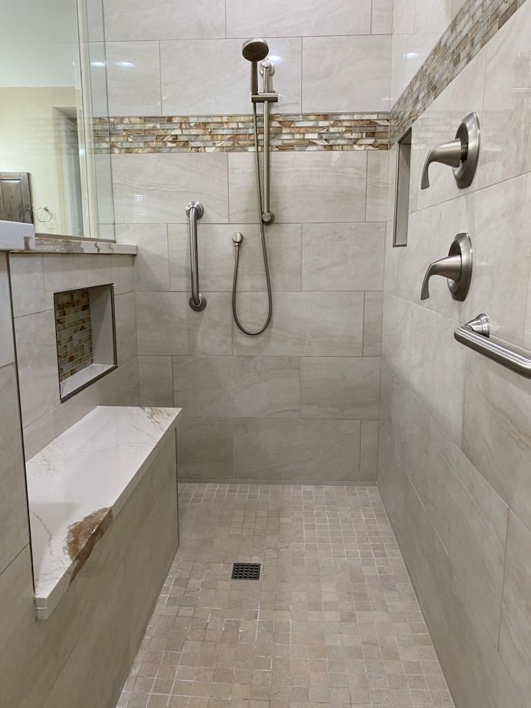 Walk-in tiled shower with bench, niche and mosaic accent band