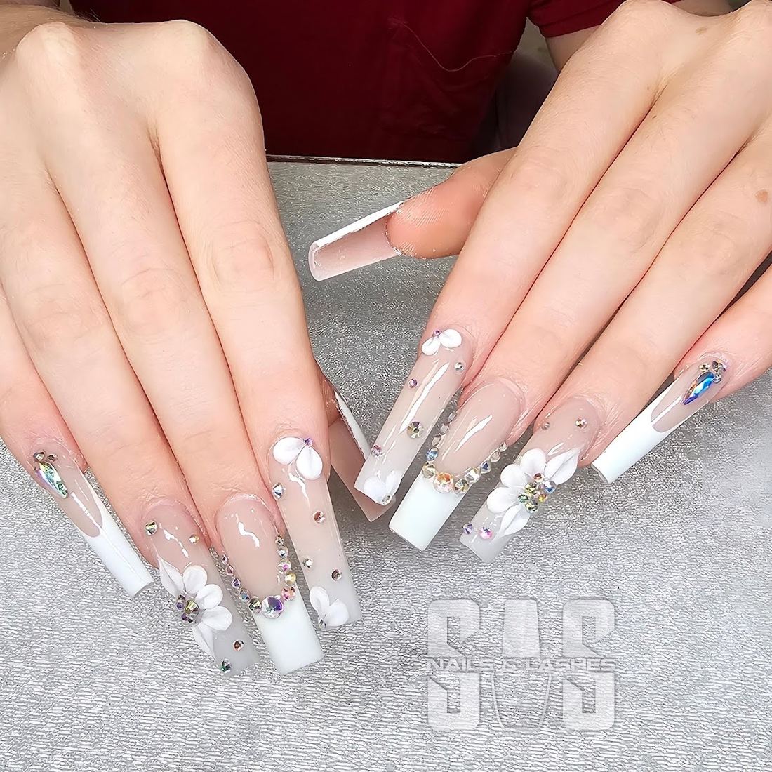 Long coffin nails with white French tips, 3D flowers and rhinestones