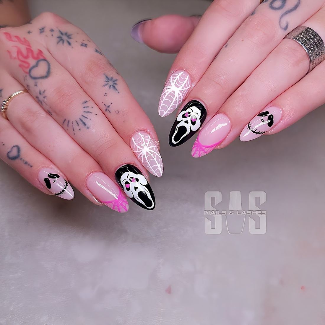Pink almond nails with black ghost face and spiderweb art