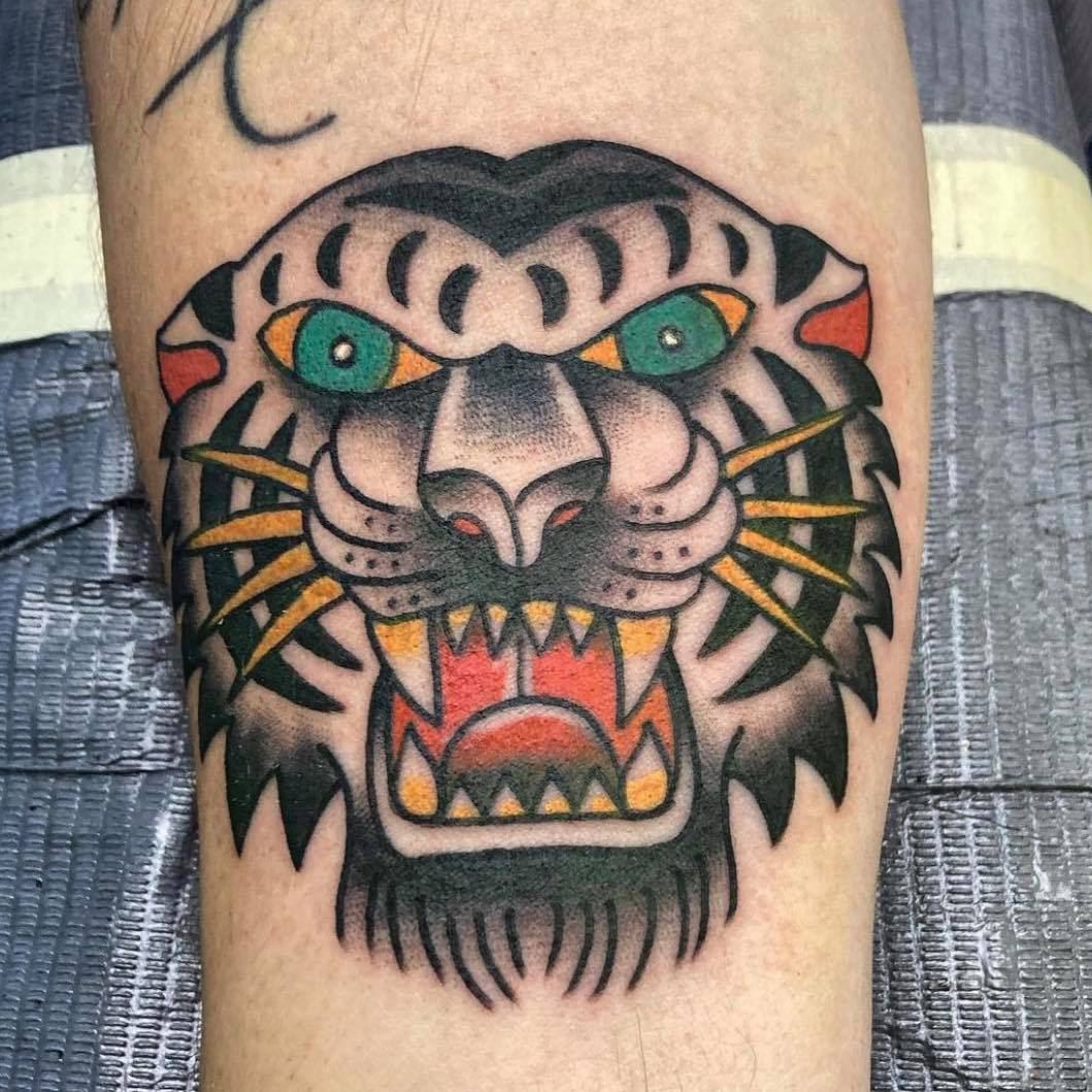 Traditional style tiger head tattoo with green eyes and bold color