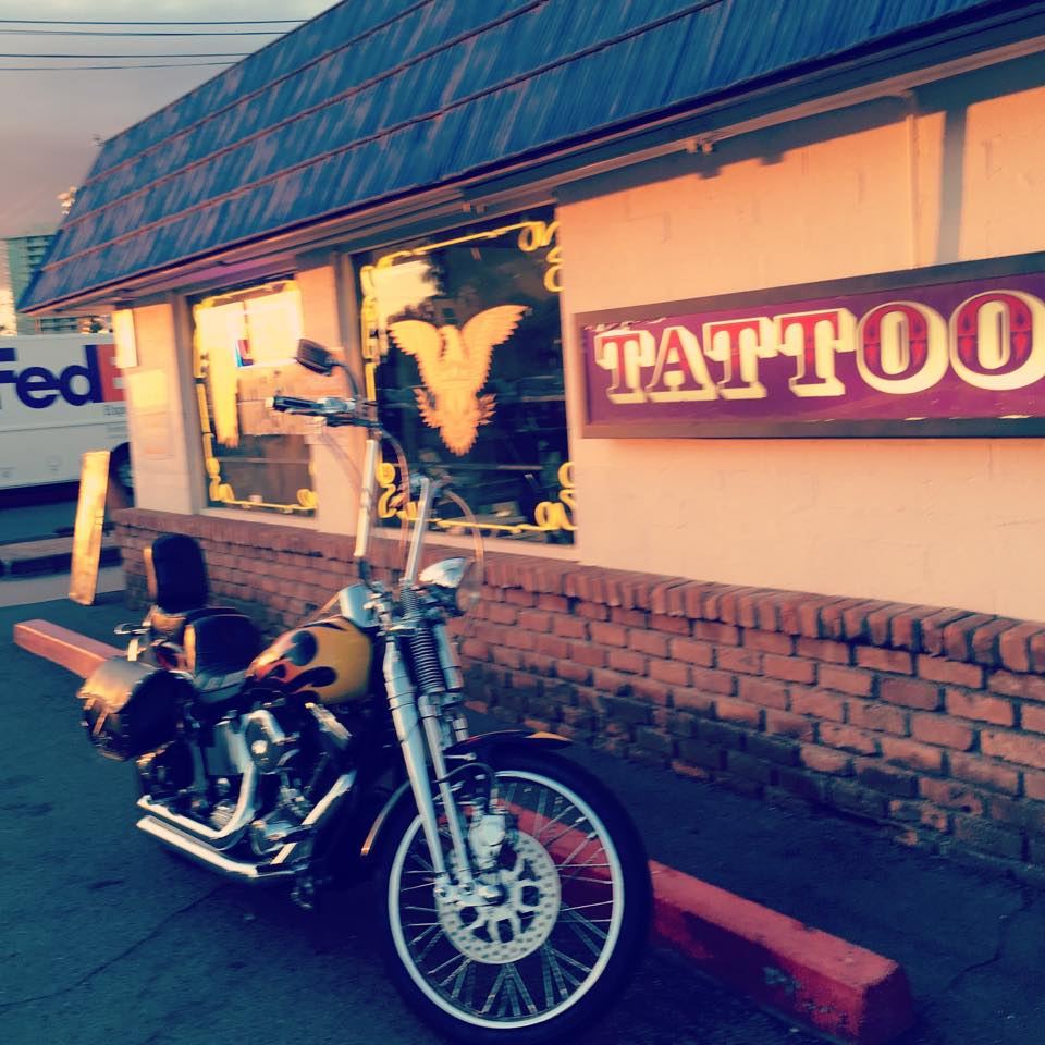 Tattooed Planet storefront on University Drive with a motorcycle parked out front