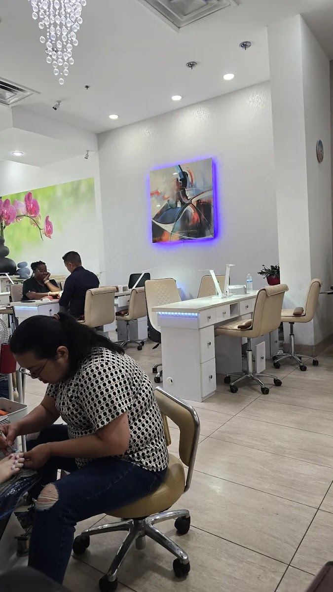 Inside The White Spa Nails: white manicure stations, a crystal chandelier and a nail tech at work