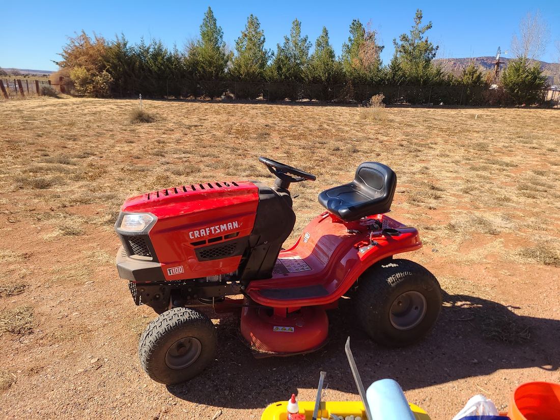Red Craftsman riding mower parked on dry ground