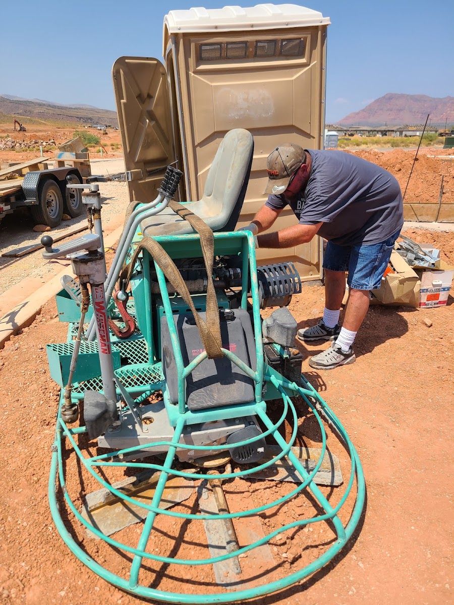 Technician working on a ride-on power trowel outdoors