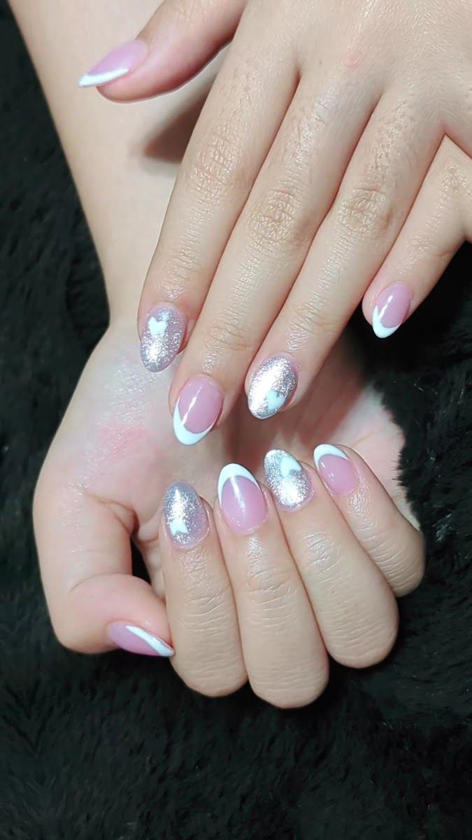 Short almond nails with white French tips and silver glitter accents