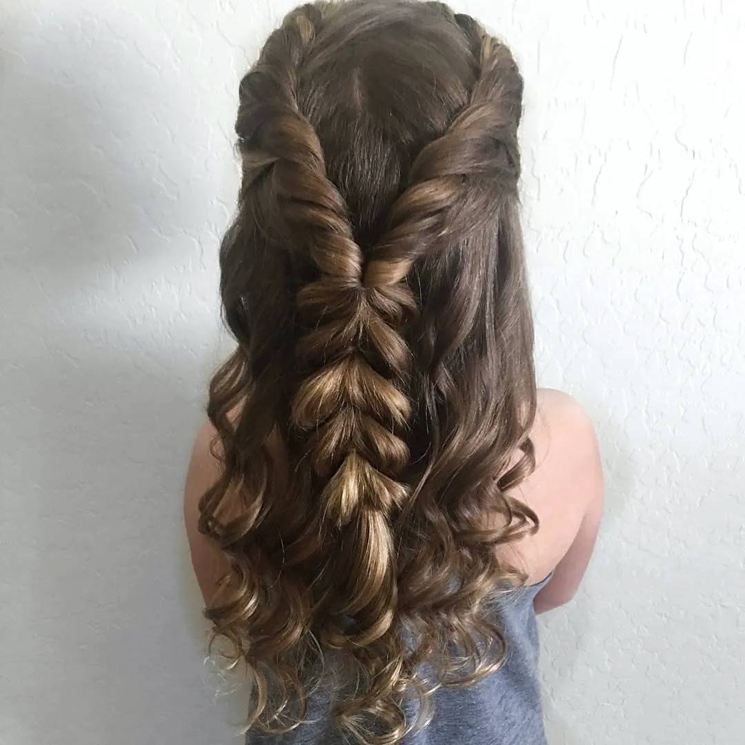 Half-up style with two fishtail braids over long brown curls