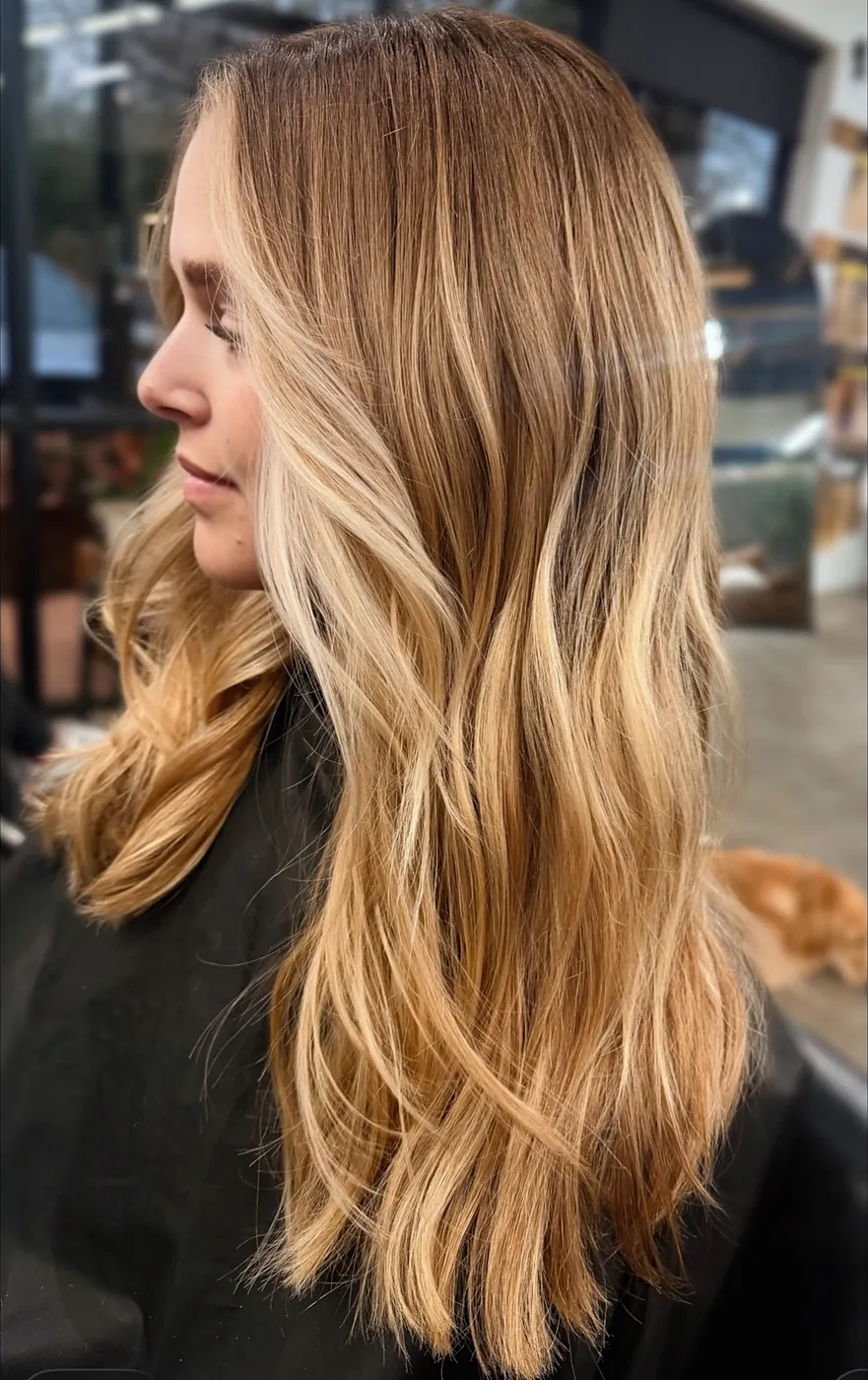 Long hair melting from copper at the top to honey blonde at the ends, seen from the side