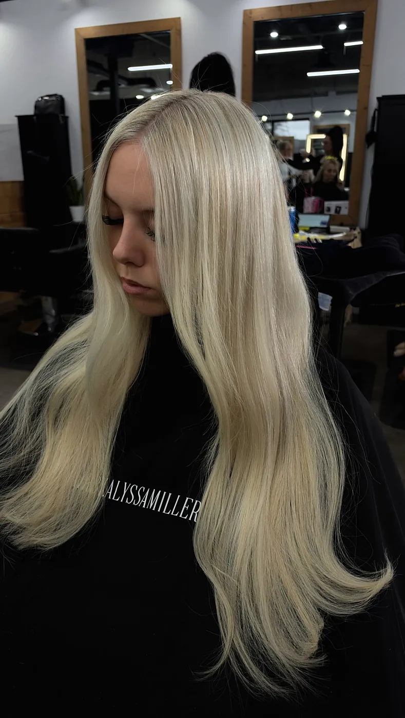 Very long straight bright blonde hair over a black cape