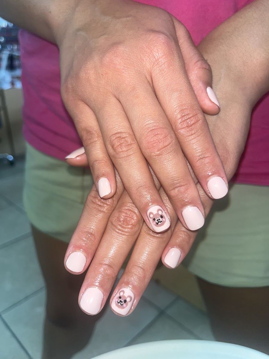 Short pale pink gel nails with two hand-painted teddy bear accent nails