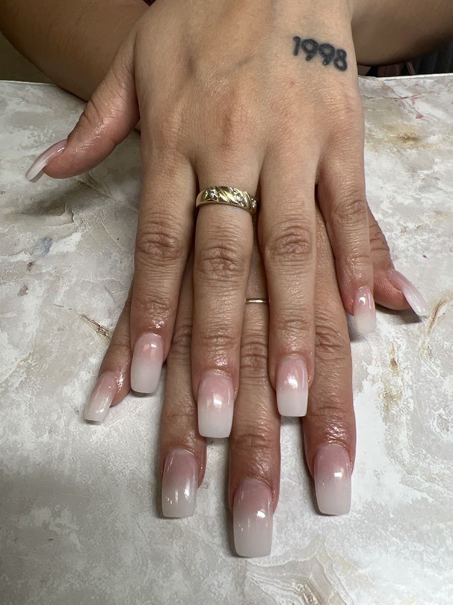 Long square acrylic nails in a soft pink to white ombre