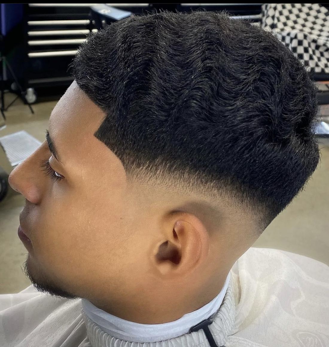 Side profile of a textured low fade with a sharp line up