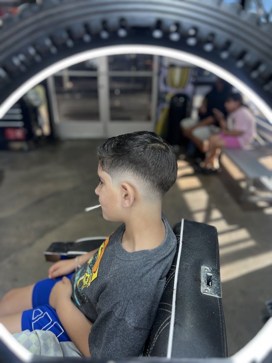 Young client in the chair showing a clean low taper