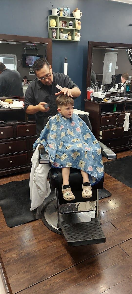 Barber combing a young boy's hair in a classic barber chair