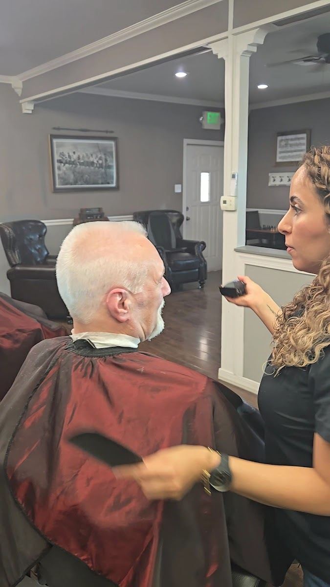 Barber finishing a cut for an older gentleman with white hair