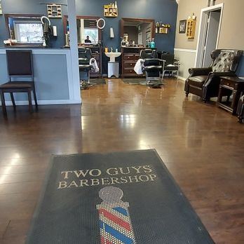Two Guys Barbershop welcome mat with a barber pole, inside the front door
