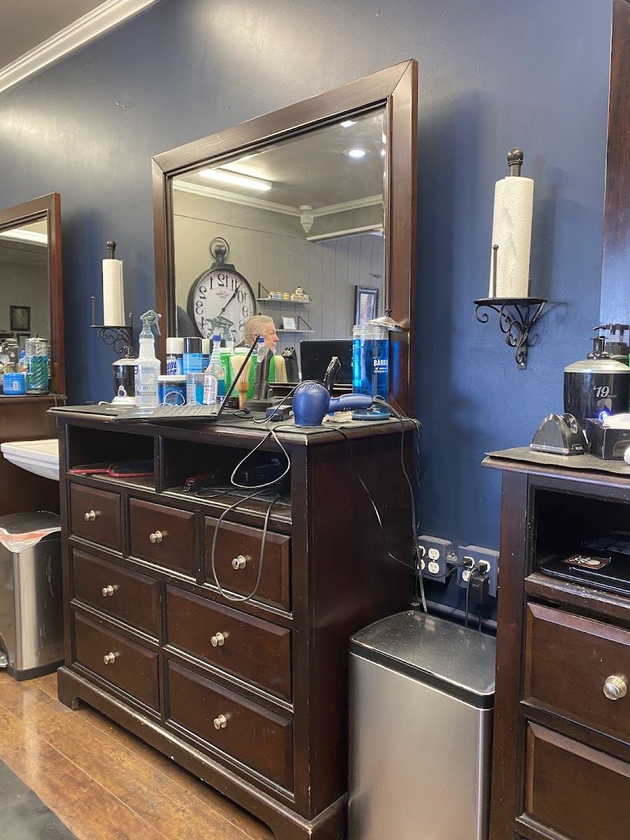 Barber station with a wood dresser, tall mirror and tools ready
