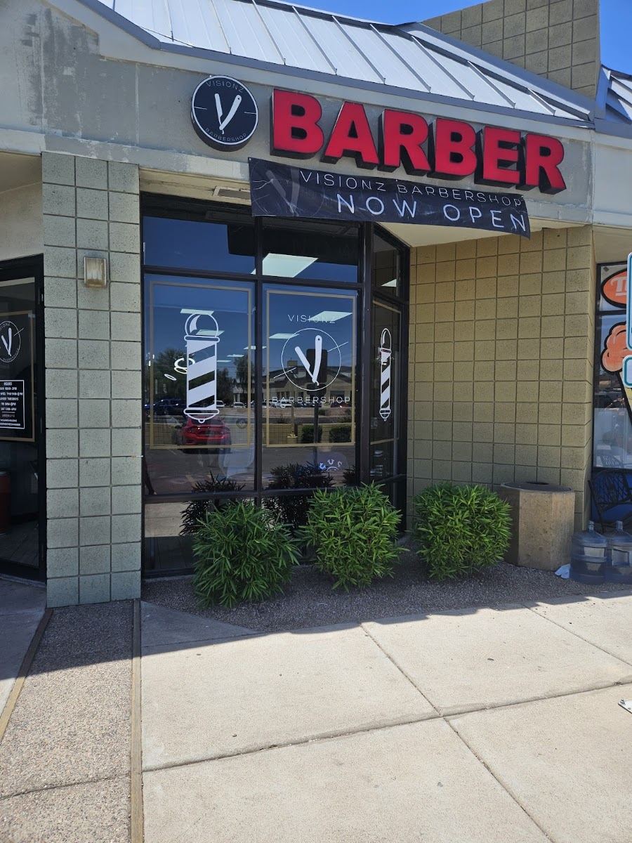 Visionz Barbershop storefront with the BARBER sign and the razor logo on the windows