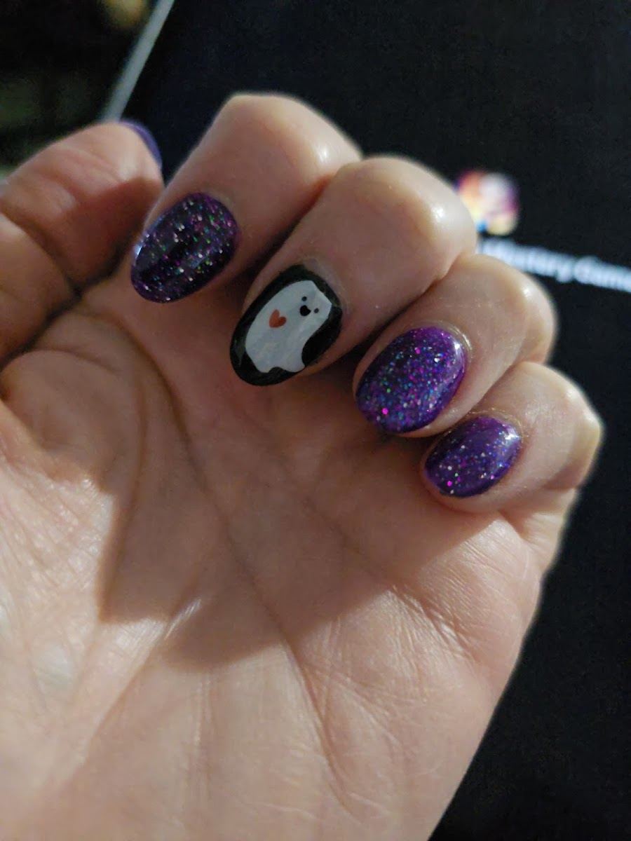 Purple glitter nails with a penguin art nail