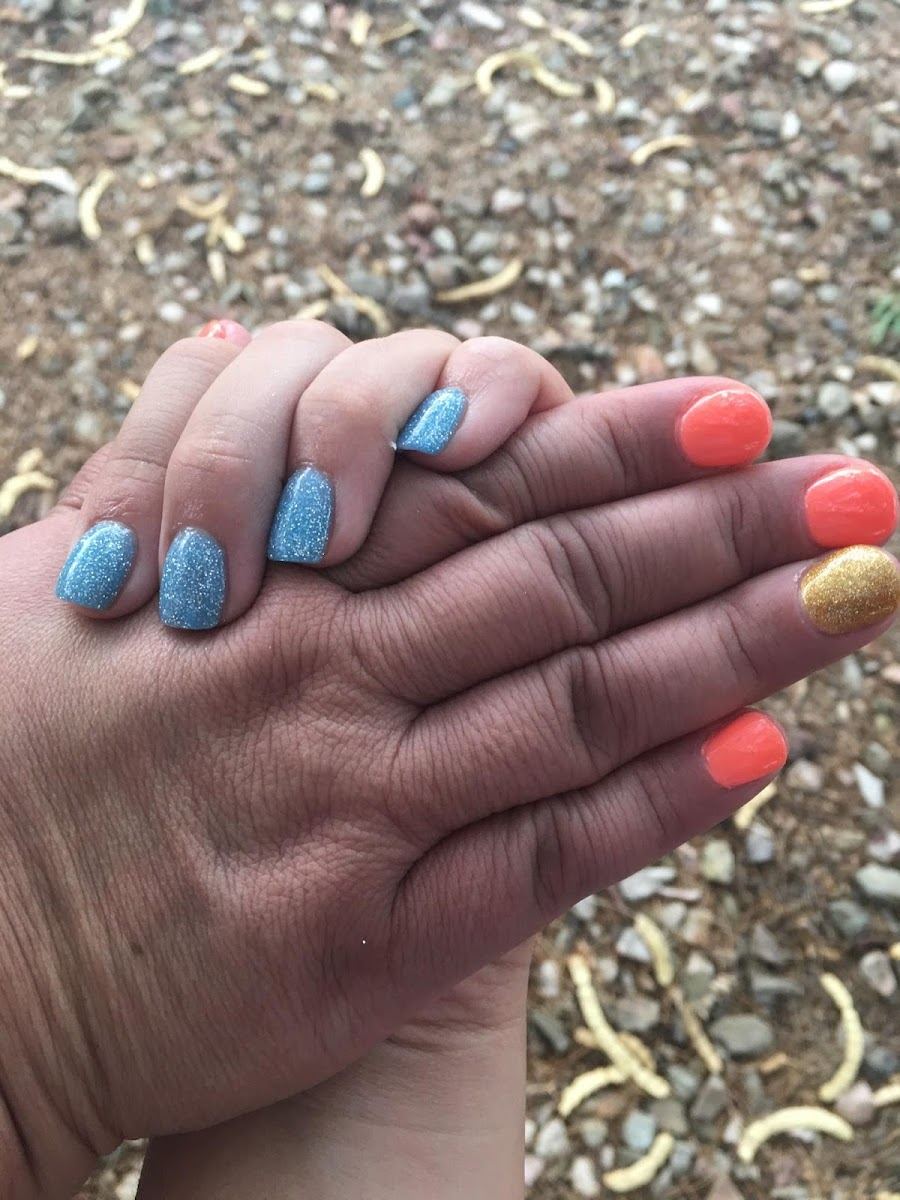 Blue glitter and coral nails on two hands