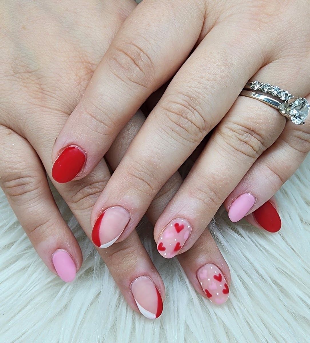 Pink and red nails with hand-painted hearts, done at Vy Vy Nails