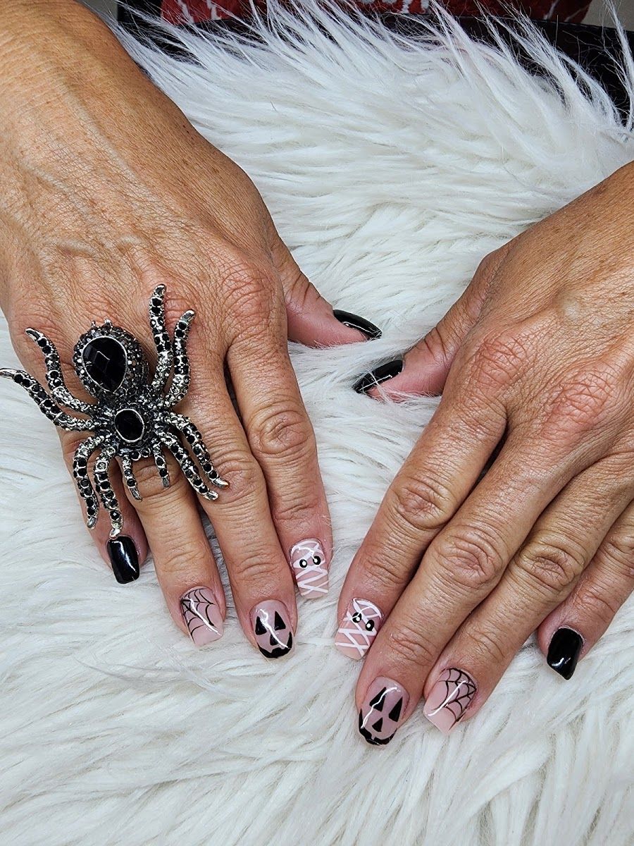 Black and nude nails with hand-painted skull art