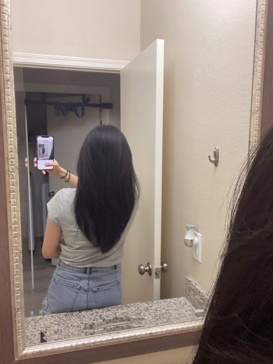 Long, sleek dark hair seen from behind in a mirror